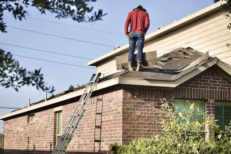 Professional roofer working on a residential roof in Village of Cantebury